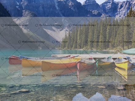 Morning light on colorful canoes along the shore of Moraine Lake, Banff National Park, Alberta, Canada.