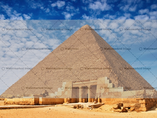 Large Ancient Egyptian pyramid against a blue sky